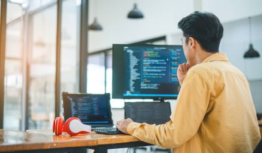 Yazılım şirketinin ofisinde kodlama, yazılım geliştirme ve web tasarımı üzerine çalışan genç bir programcı. Teknoloji geliştirme kavramı