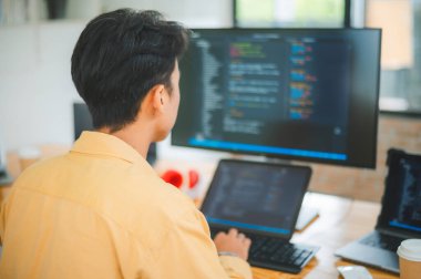 Yazılım şirketinin ofisinde kodlama, yazılım geliştirme ve web tasarımı üzerine çalışan genç bir programcı. Teknoloji geliştirme kavramı