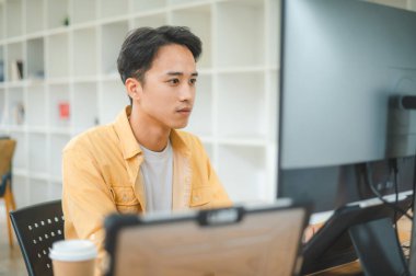 Yazılım şirketinin ofisinde kodlama, yazılım geliştirme ve web tasarımı üzerine çalışan genç bir programcı. Teknoloji geliştirme kavramı