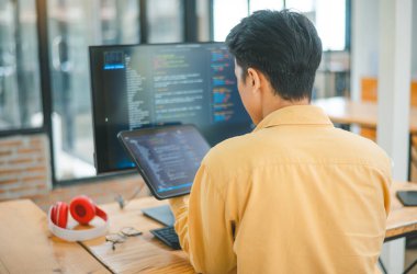 Yazılım şirketinin ofisinde kodlama, yazılım geliştirme ve web tasarımı üzerine çalışan genç bir programcı. Teknoloji geliştirme kavramı