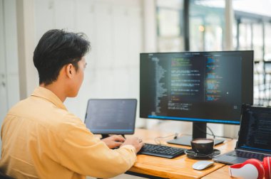 Yazılım şirketinin ofisinde kodlama, yazılım geliştirme ve web tasarımı üzerine çalışan genç bir programcı. Teknoloji geliştirme kavramı