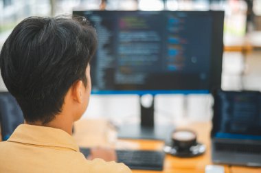 Yazılım şirketinin ofisinde kodlama, yazılım geliştirme ve web tasarımı üzerine çalışan genç bir programcı. Teknoloji geliştirme kavramı