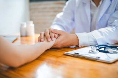 Doktor eli hastanın elini tutuyor. Hastayı cesaretlendirmek ve teselli etmek için böylece hasta üzgün ve endişeli olmaz..