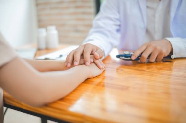 Doktor eli hastanın elini tutuyor. Hastayı cesaretlendirmek ve teselli etmek için böylece hasta üzgün ve endişeli olmaz..