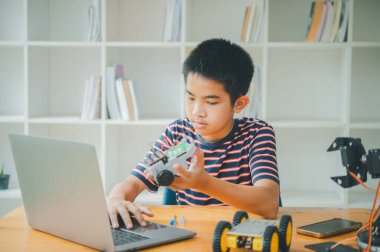 Asyalı çocuk teknoloji robotlarının çalışmalarını öğreniyor ve inceliyor. Teknoloji projesi için ev okulu ve bilim. Çocukluk çocukları hobisi eğlence yaşam tarzı oyuncakları robot teknolojisi.