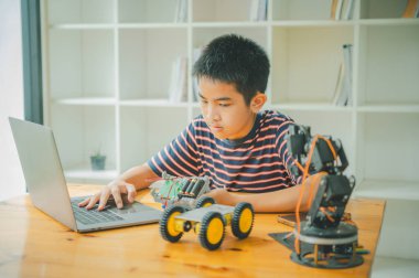 Asyalı çocuk teknoloji robotlarının çalışmalarını öğreniyor ve inceliyor. Teknoloji projesi için ev okulu ve bilim. Çocukluk çocukları hobisi eğlence yaşam tarzı oyuncakları robot teknolojisi.