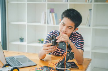 Asyalı çocuk teknoloji robotlarının çalışmalarını öğreniyor ve inceliyor. Teknoloji projesi için ev okulu ve bilim. Çocukluk çocukları hobisi eğlence yaşam tarzı oyuncakları robot teknolojisi.
