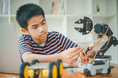 Asyalı çocuk teknoloji robotlarının çalışmalarını öğreniyor ve inceliyor. Teknoloji projesi için ev okulu ve bilim. Çocukluk çocukları hobisi eğlence yaşam tarzı oyuncakları robot teknolojisi.
