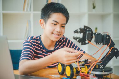 Asyalı çocuk teknoloji robotlarının çalışmalarını öğreniyor ve inceliyor. Teknoloji projesi için ev okulu ve bilim. Çocukluk çocukları hobisi eğlence yaşam tarzı oyuncakları robot teknolojisi.