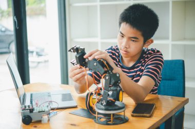 Asyalı çocuk teknoloji robotlarının çalışmalarını öğreniyor ve inceliyor. Teknoloji projesi için ev okulu ve bilim. Çocukluk çocukları hobisi eğlence yaşam tarzı oyuncakları robot teknolojisi.