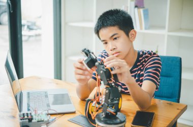 Asyalı çocuk teknoloji robotlarının çalışmalarını öğreniyor ve inceliyor. Teknoloji projesi için ev okulu ve bilim. Çocukluk çocukları hobisi eğlence yaşam tarzı oyuncakları robot teknolojisi.