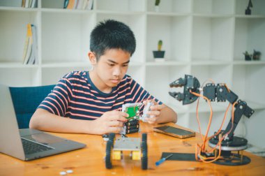 Asyalı çocuk teknoloji robotlarının çalışmalarını öğreniyor ve inceliyor. Teknoloji projesi için ev okulu ve bilim. Çocukluk çocukları hobisi eğlence yaşam tarzı oyuncakları robot teknolojisi.