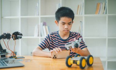 Asyalı çocuk teknoloji robotlarının çalışmalarını öğreniyor ve inceliyor. Teknoloji projesi için ev okulu ve bilim. Çocukluk çocukları hobisi eğlence yaşam tarzı oyuncakları robot teknolojisi.