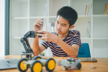 Asyalı çocuk teknoloji robotlarının çalışmalarını öğreniyor ve inceliyor. Teknoloji projesi için ev okulu ve bilim. Çocukluk çocukları hobisi eğlence yaşam tarzı oyuncakları robot teknolojisi.