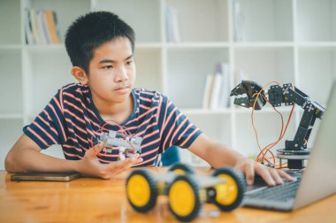 Asyalı çocuk teknoloji robotlarının çalışmalarını öğreniyor ve inceliyor. Teknoloji projesi için ev okulu ve bilim. Çocukluk çocukları hobisi eğlence yaşam tarzı oyuncakları robot teknolojisi.