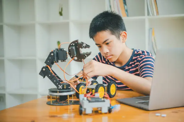Asyalı çocuk teknoloji robotlarının çalışmalarını öğreniyor ve inceliyor. Teknoloji projesi için ev okulu ve bilim. Çocukluk çocukları hobisi eğlence yaşam tarzı oyuncakları robot teknolojisi.