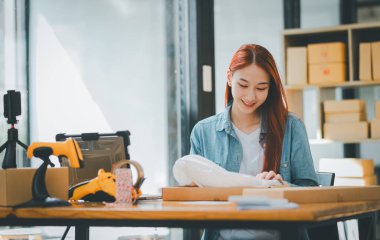 Çevrimiçi küçük işletme sahipleri sipariş ettikleri ürünleri çevrimiçi alışveriş kutusuna koyuyorlar.