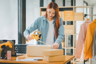 Online small business owners are packing their ordered products into the boxes for their customers based on the concept of online shopping - online shopping.