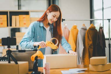 Online small business owners are packing their ordered products into the boxes for their customers based on the concept of online shopping - online shopping.