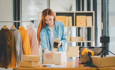 Online small business owners are packing their ordered products into the boxes for their customers based on the concept of online shopping - online shopping.