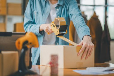 Online small business owners are packing their ordered products into the boxes for their customers based on the concept of online shopping - online shopping.