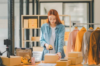 online small business owner scans a barcode-labeled parcel with a barcode scanner to verify a customer's order before it is delivered to the customer.	