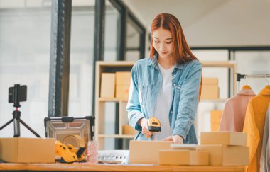 online small business owner scans a barcode-labeled parcel with a barcode scanner to verify a customer's order before it is delivered to the customer.	