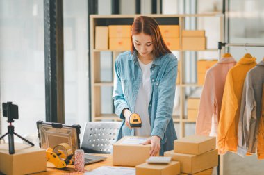 online small business owner scans a barcode-labeled parcel with a barcode scanner to verify a customer's order before it is delivered to the customer.	