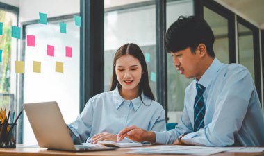 Analiz, kavramsal analiz ve iş planlaması için grafik şarj ederek ofiste birlikte çalışan ve iletişim kuran bir grup iş adamı