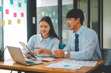 Analiz, kavramsal analiz ve iş planlaması için grafik şarj ederek ofiste birlikte çalışan ve iletişim kuran bir grup iş adamı