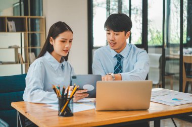 Analiz, kavramsal analiz ve iş planlaması için grafik şarj ederek ofiste birlikte çalışan ve iletişim kuran bir grup iş adamı