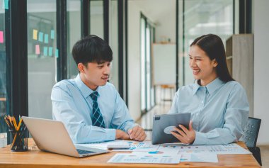 Analiz, kavramsal analiz ve iş planlaması için grafik şarj ederek ofiste birlikte çalışan ve iletişim kuran bir grup iş adamı