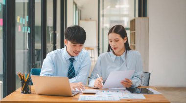 Analiz, kavramsal analiz ve iş planlaması için grafik şarj ederek ofiste birlikte çalışan ve iletişim kuran bir grup iş adamı