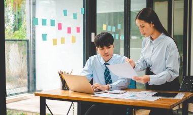 Analiz, kavramsal analiz ve iş planlaması için grafik şarj ederek ofiste birlikte çalışan ve iletişim kuran bir grup iş adamı