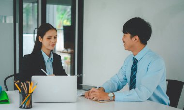 Analiz, kavramsal analiz ve iş planlaması için grafik şarj ederek ofiste birlikte çalışan ve iletişim kuran bir grup iş adamı