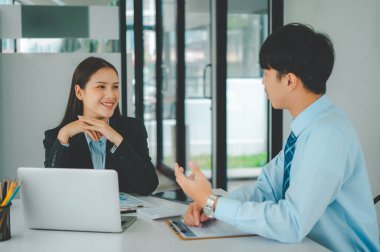 Analiz, kavramsal analiz ve iş planlaması için grafik şarj ederek ofiste birlikte çalışan ve iletişim kuran bir grup iş adamı