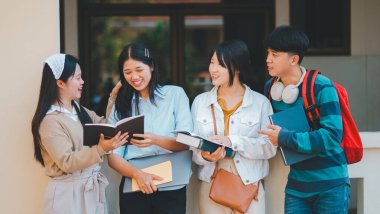 Bir grup genç üniversite öğrencisi ödev yaparken danışmanlık yapıyor, araştırma planında işbirliği yapıyor kavramları ve stratejileri tartışıyorlar. Dizüstü bilgisayarlarda ve tablet bilgisayarlarda sunumları hazırlayın.