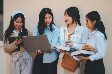 Bir grup genç üniversite öğrencisi ödev yaparken danışmanlık yapıyor, araştırma planında işbirliği yapıyor kavramları ve stratejileri tartışıyorlar. Dizüstü bilgisayarlarda ve tablet bilgisayarlarda sunumları hazırlayın.