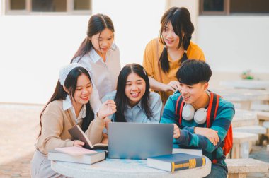 Bir grup genç üniversite öğrencisi ödev yaparken danışmanlık yapıyor, araştırma planında işbirliği yapıyor kavramları ve stratejileri tartışıyorlar. Dizüstü bilgisayarlarda ve tablet bilgisayarlarda sunumları hazırlayın.