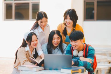 Bir grup genç üniversite öğrencisi ödev yaparken danışmanlık yapıyor, araştırma planında işbirliği yapıyor kavramları ve stratejileri tartışıyorlar. Dizüstü bilgisayarlarda ve tablet bilgisayarlarda sunumları hazırlayın.