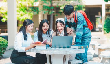 Bir grup genç üniversite öğrencisi ödev yaparken danışmanlık yapıyor, araştırma planında işbirliği yapıyor kavramları ve stratejileri tartışıyorlar. Dizüstü bilgisayarlarda ve tablet bilgisayarlarda sunumları hazırlayın.