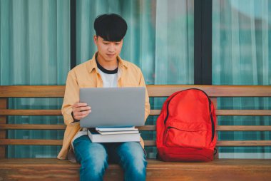 Öğrenciler, üniversite bölgesindeki dizüstü bilgisayarlardan araştırma yapıp bilgi topluyorlar..