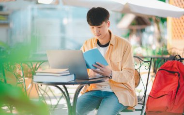 Öğrenciler, üniversite bölgesindeki dizüstü bilgisayarlardan araştırma yapıp bilgi topluyorlar..