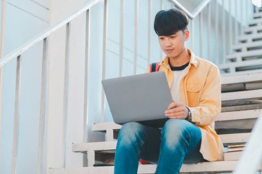 Öğrenciler, üniversite bölgesindeki dizüstü bilgisayarlardan araştırma yapıp bilgi topluyorlar..