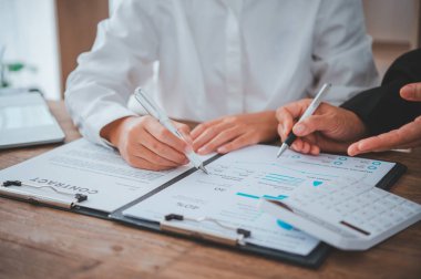 İş ekibi dizüstü bilgisayar ve açık alan Office hesap makinesi çalışıyor. Toplantı rapor devam ediyor