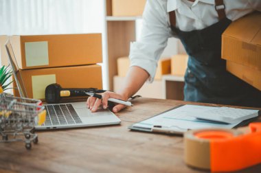 Küçük KOBİ işletme sahipleri iş yerinde dizüstü bilgisayarlarla çalışıyorlar. Ve nakledilmeye hazır ürünlerimiz var. Müşteriler çevrimiçi perakendecilerden, ticaretten sipariş verdi.