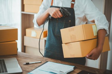 Müşteriler için ürünleri kontrol etmek için barkod tarayıcı ile karton kutu tarama personeli