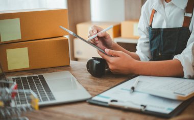 Küçük KOBİ işletme sahipleri iş yerinde dizüstü bilgisayarlarla çalışıyorlar. Ve nakledilmeye hazır ürünlerimiz var. Müşteriler çevrimiçi perakendecilerden, ticaretten sipariş verdi.