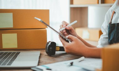 Küçük KOBİ işletme sahipleri iş yerinde dizüstü bilgisayarlarla çalışıyorlar. Ve nakledilmeye hazır ürünlerimiz var. Müşteriler çevrimiçi perakendecilerden, ticaretten sipariş verdi.