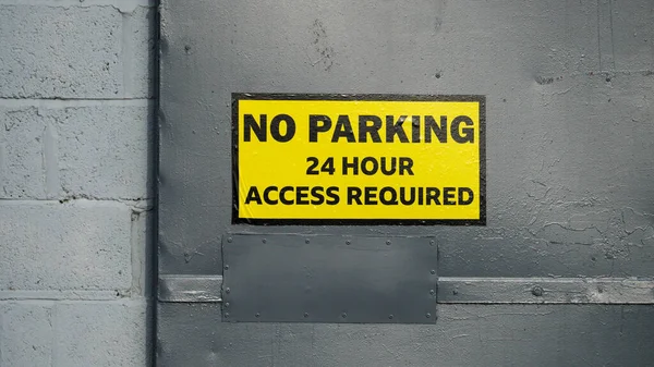No parking signs on industrial units due to access requirements for industrial units. Black letters on yellow background,